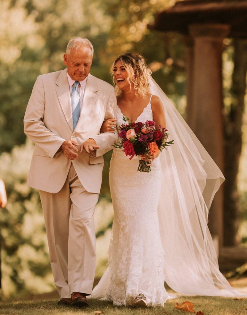 bride and father walk down aisle at rushmore estate wedding